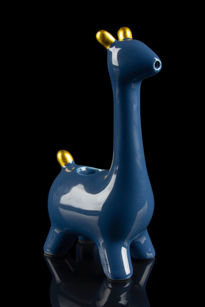 Blue ceramic giraffe-shaped water pipe with gold horns, reflecting on a black surface.