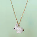 Camp Hollow Porcelain Goldentail Rabbit Necklace on green background.