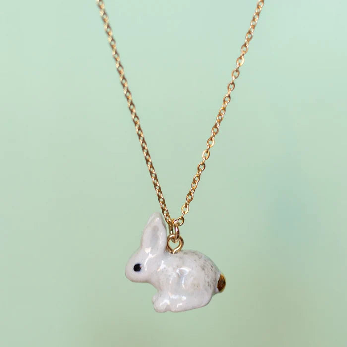 Camp Hollow Porcelain Goldentail Rabbit Necklace on green background.