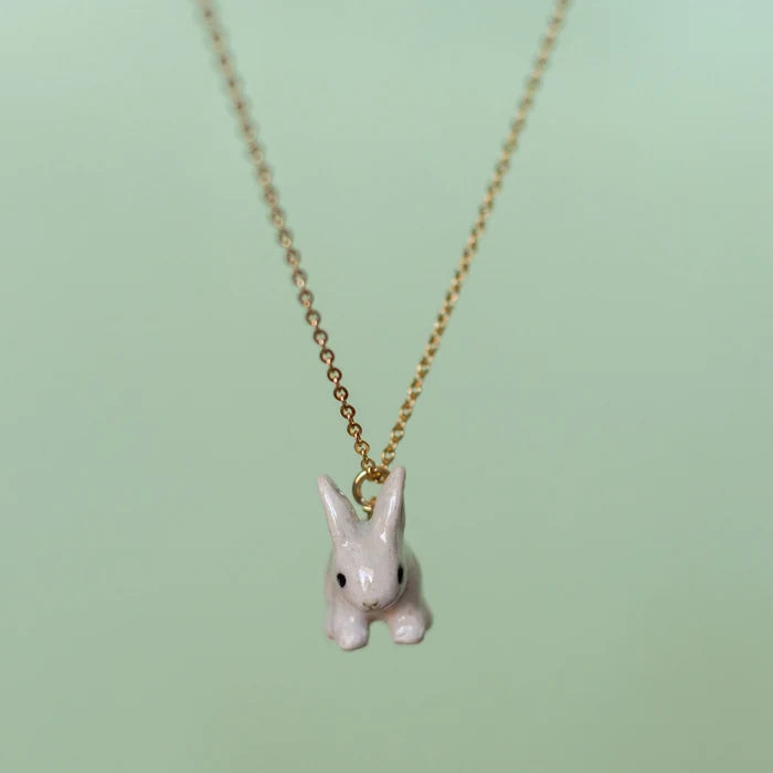 Camp Hollow Porcelain Goldentail Rabbit Necklace on green background.