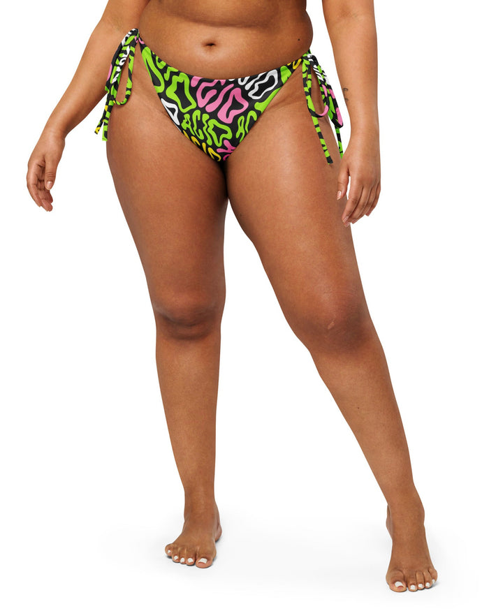 The front of the Candy Acid Recycled String Bottoms by One Stop Rave on a model.