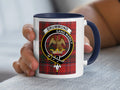 Drummond clan crest mug with Gang Warily motto — tartan background, held in hand
