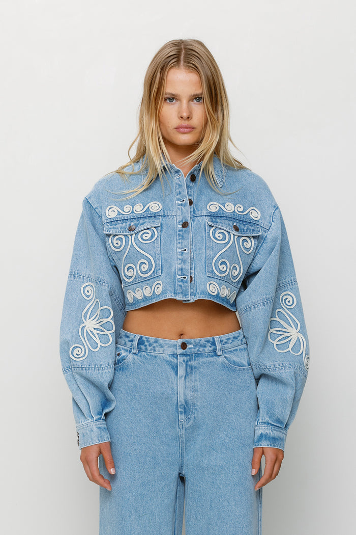 Cropped cotton denim jacket with oversized balloon sleeves and custom embroidery by The Wolf Gang, pairs with matching barrel jeans.