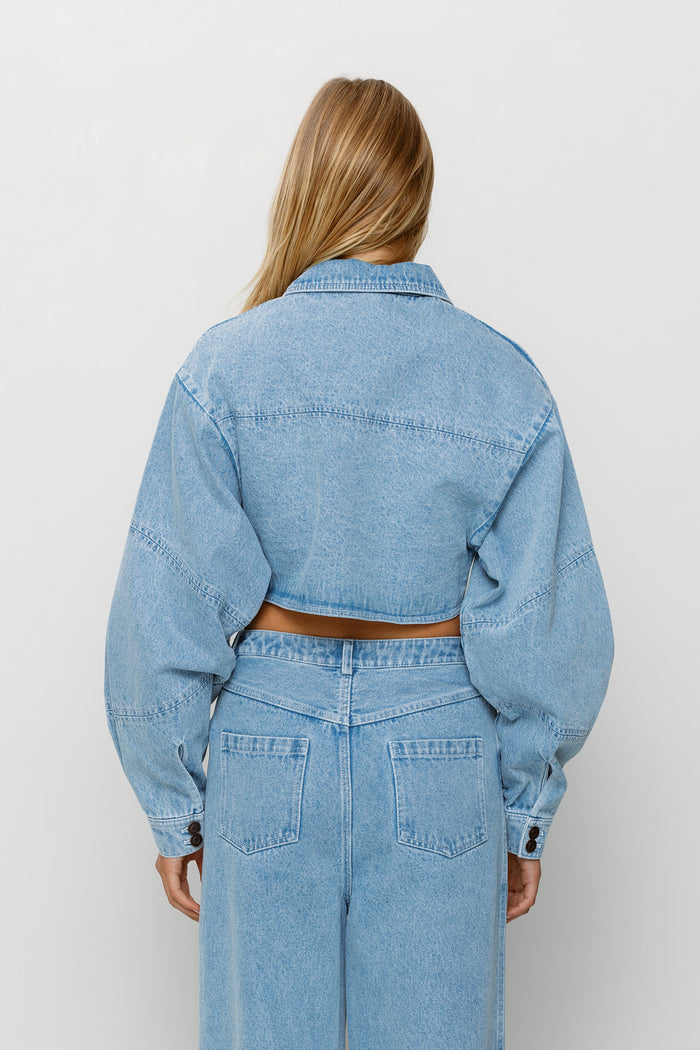 Cropped cotton denim jacket with oversized balloon sleeves and custom embroidery by The Wolf Gang, pairs with matching barrel jeans.