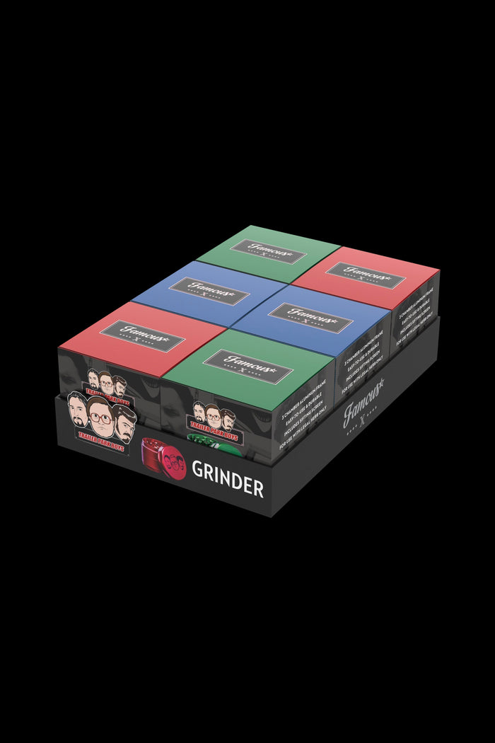 A stack of six “Famous” branded cannabis grinders in various colors—red, green, blue, pink, and black—against a black background. Each grinder features a central logo and text indicating it’s for legal use only.