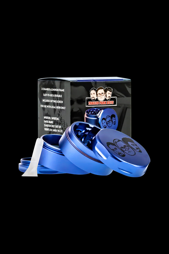 Blue metal grinder with “Trailer Park Boys” branding, partially open with cannabis visible inside."