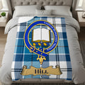 Hill clan crest with Veritas Superabit Montes motto on blue tartan throw
