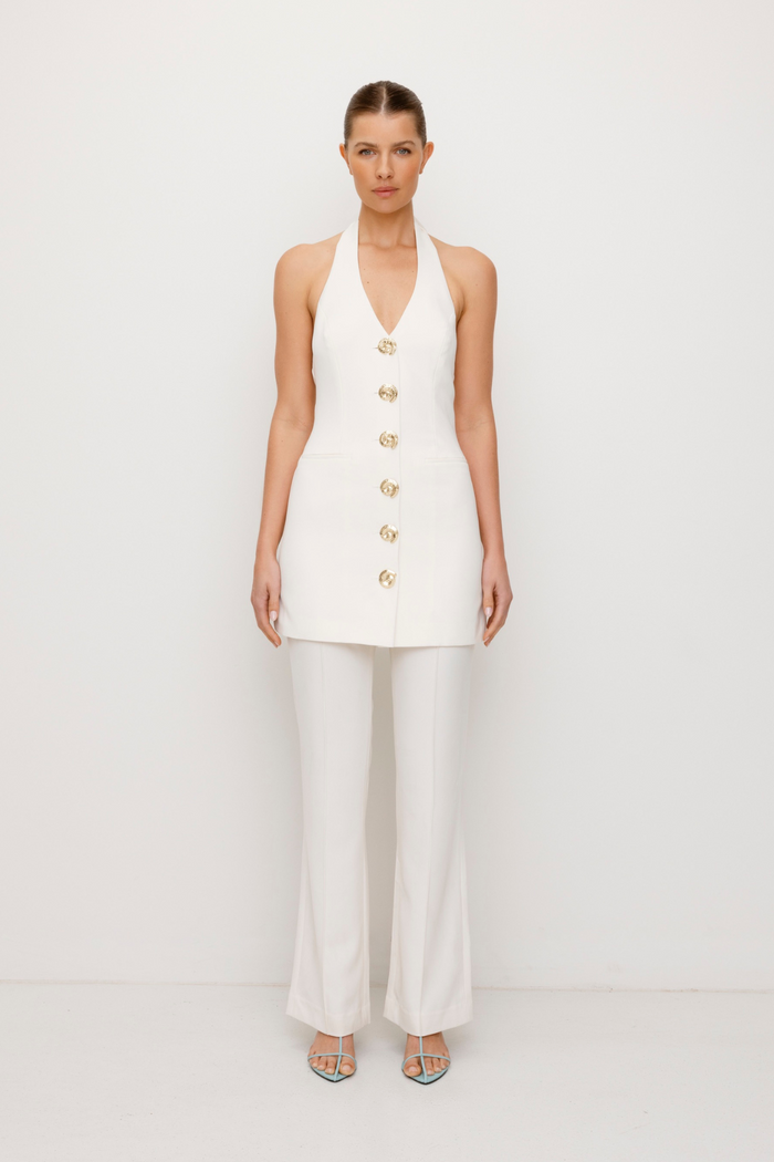 Best-selling women’s Ivory White Irida mini halter neck vest dress with gold swirl buttons, tie-back, and front welt pocket—wear alone or with matching pants. Perfect for Brides.