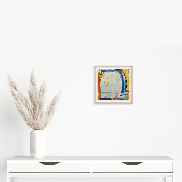 The artwork 'LS no. 26' by Janice La Motta features abstract geometric forms in vibrant yellow, blue, and orange hues on Yupo paper. Bold curved lines create dynamic movement across the 9x9 inch composition, while delicate oil pastel strokes add textural depth and translucent layering effects. Framed in white, displaying contemporary minimalist style by Janice La Motta.