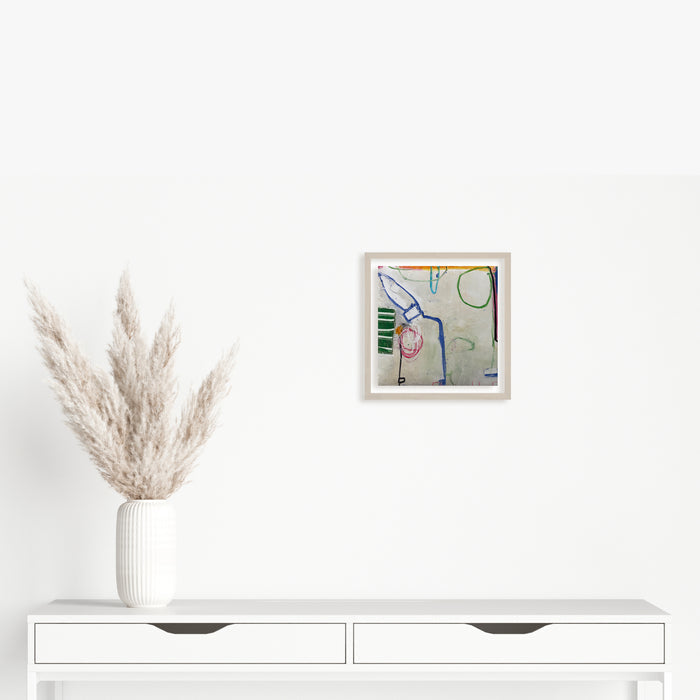 The artwork 'LS no. 5' by Janice La Motta features abstract geometric shapes and lines in blue, green, and pink against a light background. The minimalist composition showcases loose, gestural strokes in oil pastel on Yupo paper, creating a playful interplay of forms and negative space in a 9x9 inch format.