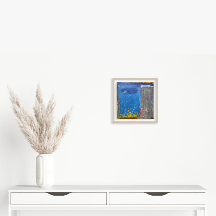 The artwork 'LS no. 7' by Janice La Motta features vibrant blue and gray abstract composition on Yupo paper, created with oil pastels. The piece showcases textural contrasts between smooth and rough areas, with hints of yellow accents along the bottom edge. The 9x9 inch artwork displays a contemporary minimalist aesthetic that balances bold color blocks with subtle artistic gestures.