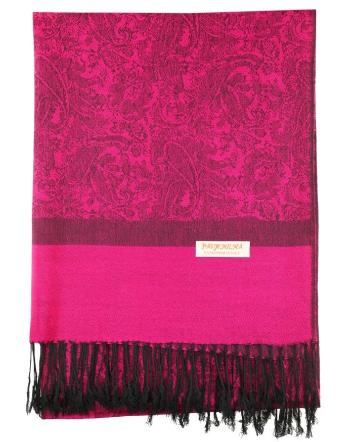 A magenta paisley rave pashmina with black fringes at the ends, draped elegantly around a model.