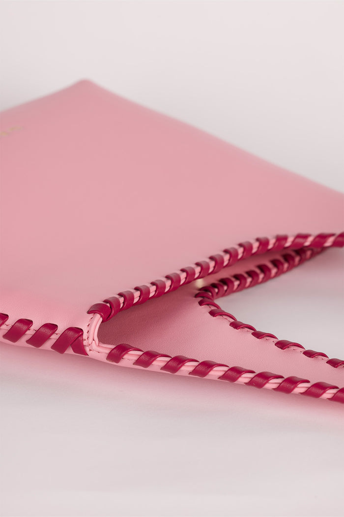 Women’s Candy Pink Mara Shoulder Bag in 100 percent leather with twisted strap contrast binding and magnetic snap closure for everyday wear.