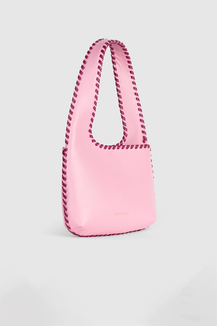 Women’s Candy Pink Mara Shoulder Bag in 100 percent leather with twisted strap contrast binding and magnetic snap closure for everyday wear.