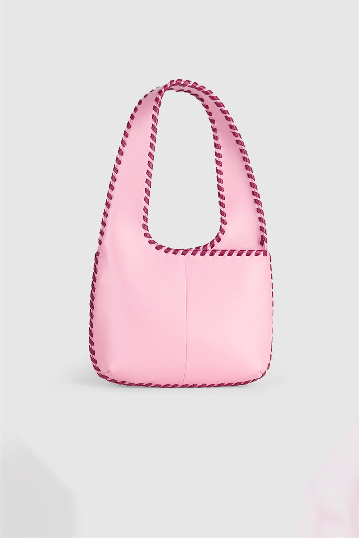 Women’s Candy Pink Mara Shoulder Bag in 100 percent leather with twisted strap contrast binding and magnetic snap closure for everyday wear.