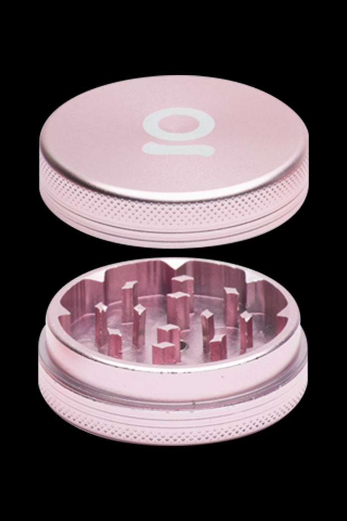 Pink metal cannabis grinder, disassembled to show the teeth and chamber.