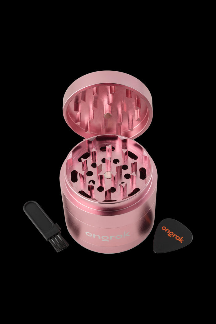 Rose gold four-piece grinder with open lid and included scoop and scraper, branded "onorok".