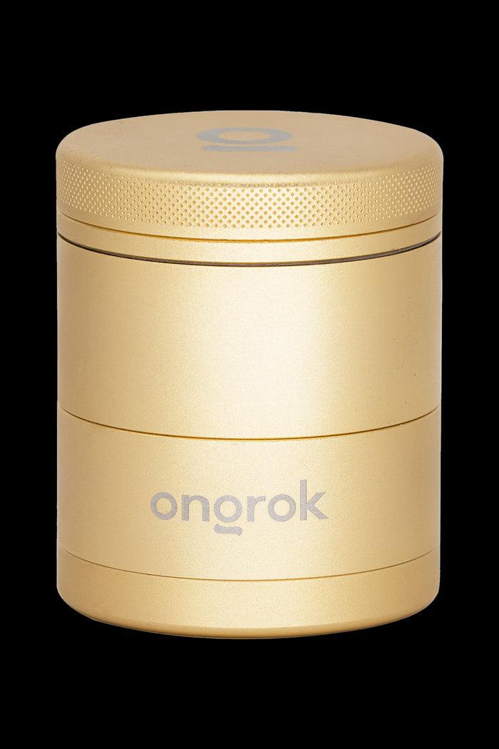 Gold cannabis grinder with “ongrok” logo.
