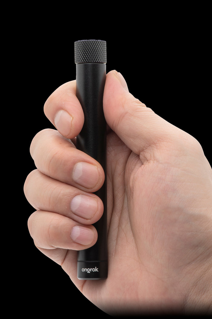 Hand holding a sleek, black cannabis vaporizer with “ongrok” branding.