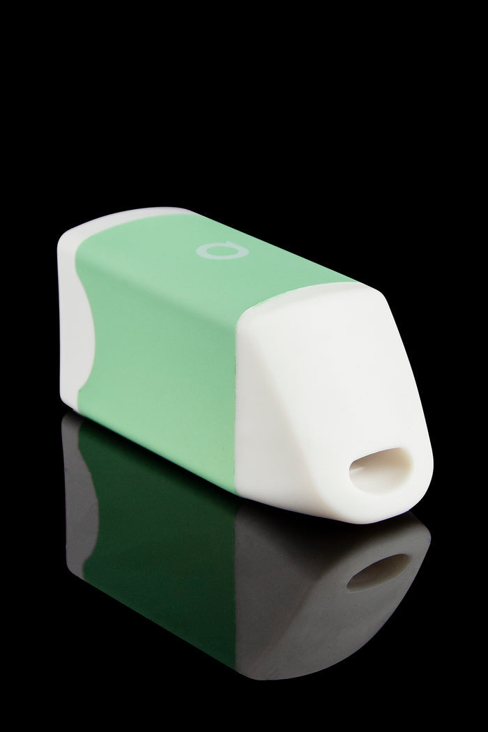 Mint green and white cannabis oil applicator with a rounded tip, displayed on a reflective black surface.