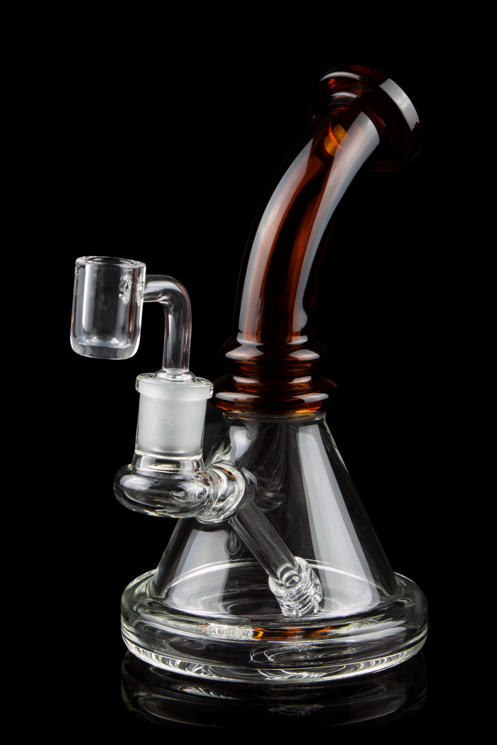 A clear glass rig with a colored mouthpiece and a quartz banger, isolated on a black background.
