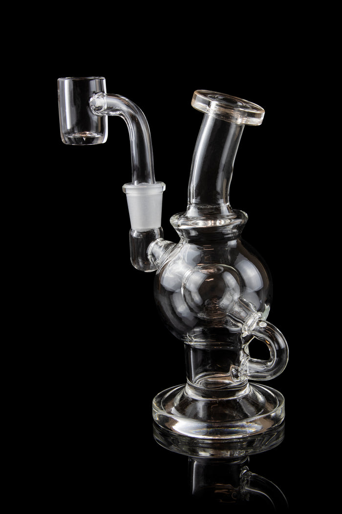 Clear glass dab rig with a bubbler and quartz nail, isolated on black.