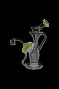 Angled close-up of the clear glass Power Button Recycler Rig with milky green accent rings against a black background
