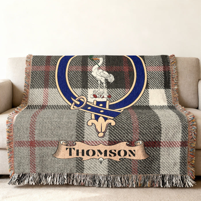 Thomson woven blanket draped over a sofa with crest