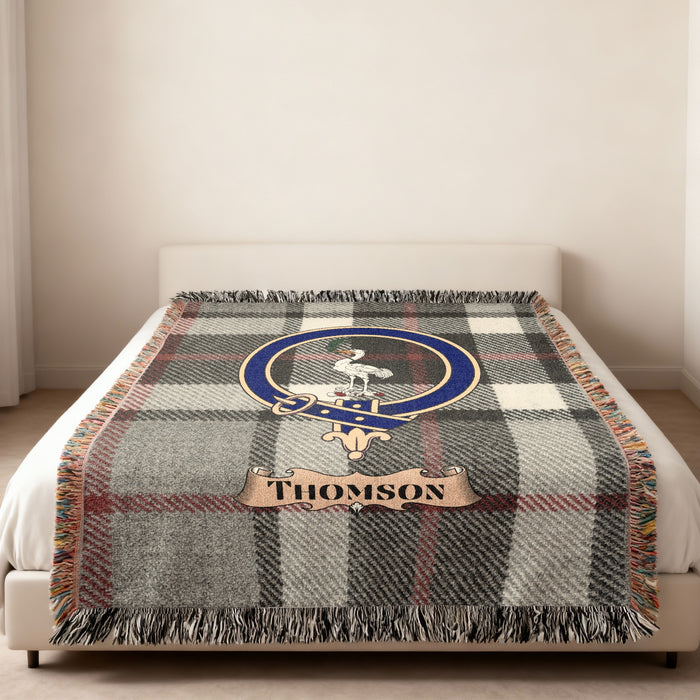 Thomson woven blanket on bed with name over tartan background